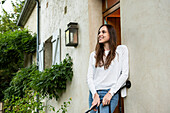 Smiling young woman looking away at doorstep