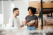 Male and female entrepreneur discussing while taking inventory