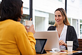 Medium shot of two female co-workers talking about business topics in outdoors office