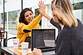 Shot of two female work mates high-fiving each other while working outdoors