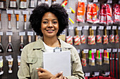 African American hardware shop worker looking at the camera while holding clipboard