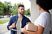 Delivery man talking with African American female customer