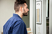 Delivery man standing in doorway while waiting to be attended