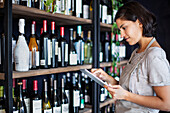 Weinhändlerin beim Einrichten des Online-Shops mit digitalem Tablet