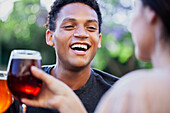 Fröhlicher lateinamerikanischer Mann hat Spaß beim Biertrinken mit Freunden