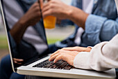 Close up shot of woman's hands typing on a laptop computer's keyboard