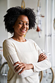 Mittlere Einstellung einer afroamerikanischen Unternehmerin, die in die Kamera schaut, während sie in ihrem Geschäft steht