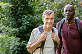 Two male friends hiking in the woods stop to take a picture