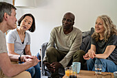 Two senior couples talking while gathered in living room