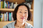 Senior Asian woman looking at the camera while sitting indoors