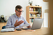 Älterer Geschäftsmann bei einem Online-Meeting im Home-Office