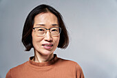Reife asiatische Amerikanerin mit Blick in die Kamera