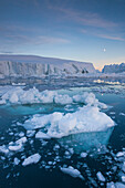 Greenland, Disko Bay, Ilulissat, floating ice at sunset with moonrise