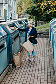 Woman putting cardboard in recycling bin