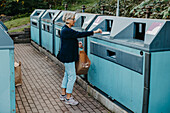Frau wirft Müll in die Wertstofftonne