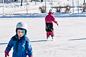Children ice skating in winter