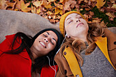 Friends lying on ground in autumn scenery