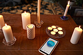 Kerzen und Telefon mit Temperatur-App