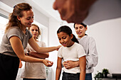 Teachers and children in first aid class