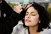 Young woman having her make-up done