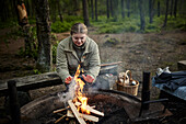 Woman sitting near campfire