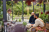 Smiling friends talking in greenhouse