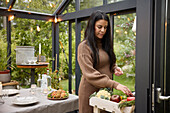 Woman in greenhouse preparing meal