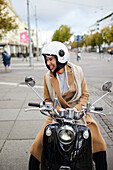 Smiling woman sitting on scooter