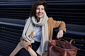 Smiling businesswoman sitting on bench