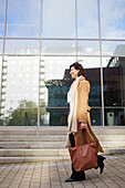 Smiling businesswoman outside office building