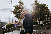 Senior couple using smart phone in city