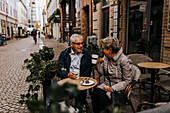 Älteres Paar trinkt Kaffee in einem Straßencafé