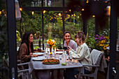 Smiling female friends in greenhouse