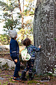 Children looking at carvings on rock