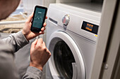 Person checking energy use for washing machine