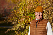 Porträt eines älteren Mannes in einer Herbstlandschaft