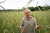 Ältere Frau geht in einem Feld spazieren