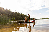 Kids paddleboarding on lake