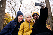 Three friends taking selfie in park