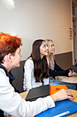 Teenagers sitting and talking on school corridor