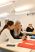 Teenager-Mädchen telefonieren im Klassenzimmer