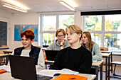 Teenage boys using laptops in classroom