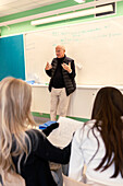 Teenage kids and teacher in classroom