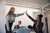 Business people high fiving during meeting in office