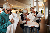 Senior women holding dressing gowns in spa