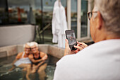 Ältere Frau fotografiert mit Handy