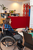 Woman on wheelchair working on laptop