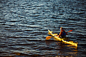 Man in yellow kayak holding oar