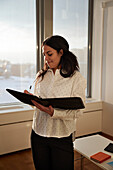 Smiling young woman taking notes