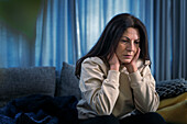 Depressed woman sitting in living room